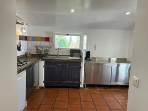 a kitchen with stainless steel appliances and a tile floor at Les Mazets du Paty in Albaron