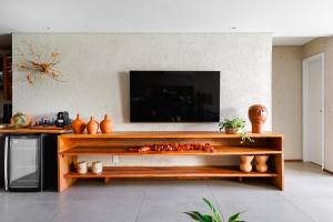 a living room with a television and a wooden table at Casa Playa Milagres in São Miguel dos Milagres +23 photos