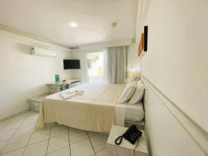 a bedroom with a large bed with a window at New Casablanca Praia Hotel in Paulista
