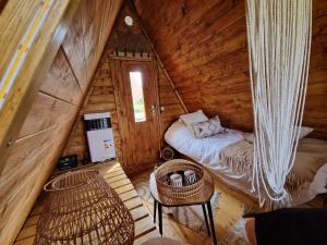 a room with a bed and a table in a cabin at Cabane Indiana - SPA du Souffle du Saule in Buhl-Lorraine