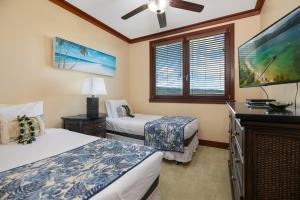 a bedroom with two beds and a flat screen tv at Ko Olina Beach Villas O1406 in Kapolei +28 photos