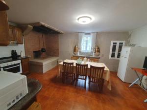 a kitchen with a table and chairs and a kitchen with a stove at Casa en zona rural in Cervo +11 photos