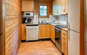 a kitchen with wooden cabinets and a white refrigerator at Älgen in Fegen