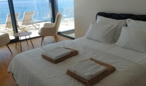 ein Schlafzimmer mit einem Bett mit zwei Handtüchern darauf in der Unterkunft Sea Cliff Villa in Bar + 85 Fotos