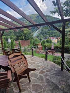 a wooden bench sitting on a patio with a view at Pensjonat Gościniec Szczyrk , z sauną i jacuzzi in Szczyrk
