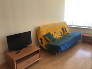 a living room with a couch and a tv at Privilege Accommodation in Elenite