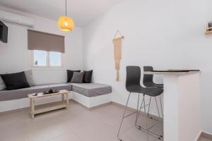 a white living room with a couch and a table at ALTHEA PAROS in Naousa