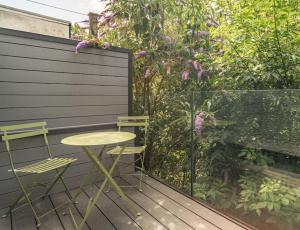 a table and two chairs on a wooden deck at Cottage Cwtch in Pont-Nedd-Fechan