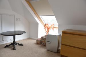 une chambre avec une table, un tabouret et une fenêtre dans l'établissement Jaffas Loft Room, à Londres