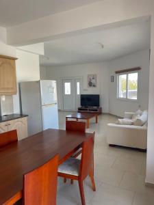a kitchen and living room with a table and a couch at Valentine Family Villa in Kiti