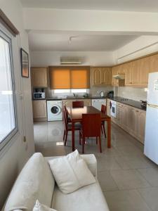 a kitchen with a white couch and a table in a room at Valentine Family Villa in Kiti