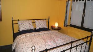 a bedroom with a large bed with pink sheets and a window at Fleurs-Sauvages in Hebronval