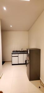 an empty kitchen with a sink and a refrigerator at قصر أباهي للوحدات السكنية المفروشة in Al Kharj