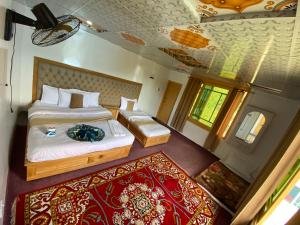 a bedroom with a large bed and a red rug at Habib Green Cottage in Upper Neelun