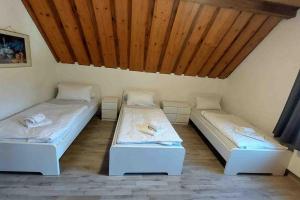 two beds in a room with wooden ceilings at WA122 - Große Monteurwohnung Übergangswohnung in Wackersdorf