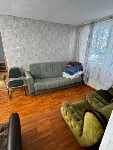 a living room with a couch and a chair at Vasaras mājiņa pie Rāznas ezera Nr 23 in Ragi