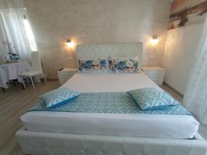 a bedroom with a large white bed with blue pillows at Viola di Mare Rooms and Parking in Termoli