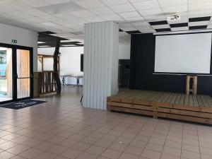 a large screen on a wall in a room at Le Domaine des Pins in Saint-Hilaire-de-Riez