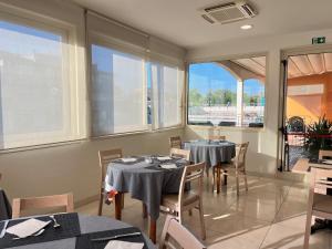 jadalnia ze stołami, krzesłami i oknami w obiekcie Hotel Berenice w Rimini +83 zdjęcia