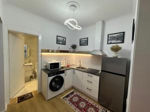 a kitchen with a refrigerator and a washing machine at SEN Garden Home in Tirana
