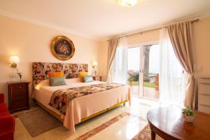 Un dormitorio con una cama y una ventana grande. en La Perla Exotica, en Los Realejos 100 fotos más
