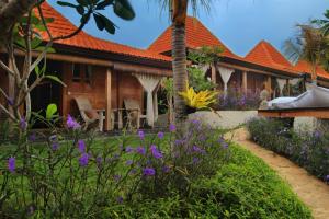 a house with purple flowers in front of it at Yoga Searcher Bali in Uluwatu