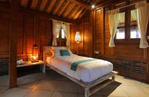 a bedroom with a bed in a room with wooden walls at Yoga Searcher Bali in Uluwatu +11 photos