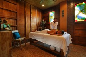 a woman laying on a bed in a room with a man at Yoga Searcher Bali in Uluwatu