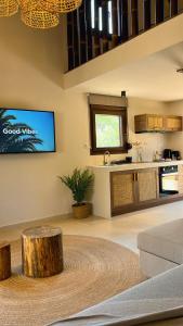 a living room with a tree stump coffee table and a kitchen at Palma Seaside Villa 3 in Sarti