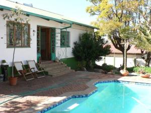 a house with a swimming pool in front of a house at For the Single Traveller close to town in Windhoek