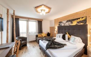 a hotel room with a bed and a living room at Natur & Aktiv Hotel Rogen in Mühlbach +65 photos
