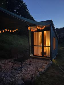 a small shed with a table and a chair in front at Villa Lugina in Fushë-Buall