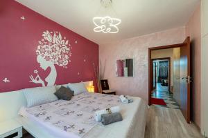 a bedroom with a large bed and a red wall at Apartments Rosina in Plovdiv