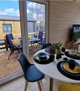una sala da pranzo con tavolo e sedie e un balcone di Tiny House Finja - Wohlfühldomizil am Plauer See a Stuer