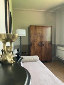 une chambre avec un lit et une armoire en bois dans l'établissement La Corte Nascosta Volpedo, à Volpedo