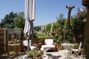 une terrasse avec un parasol, des chaises et des plantes dans l'établissement La BARBELLA, à Lourmarin