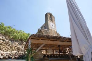 une tour d'horloge au sommet d'un bâtiment avec un parapluie dans l'établissement La BARBELLA, à Lourmarin