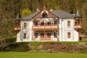 Casa blanca grande con balcón en un patio en Alpská růže, en Luhačovice