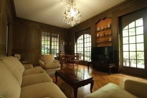 a living room with a chandelier and a couch and a table at Villa du Parc I maison de caractère, proche centre in Montauban