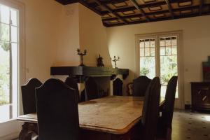 a dining room with a table and a fireplace at Villa du Parc I maison de caractère, proche centre in Montauban