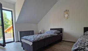 ein Schlafzimmer mit einem Bett und einem großen Fenster in der Unterkunft Apartamenty i domki letniskowe Galapagos in Okuninka