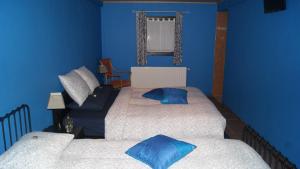 a room with two beds and a blue wall at Fleurs-Sauvages in Hebronval