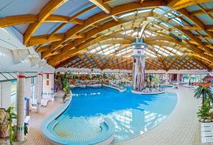 a large swimming pool in a building with a ceiling at Central Brežice Chalet & Parking in Brežice