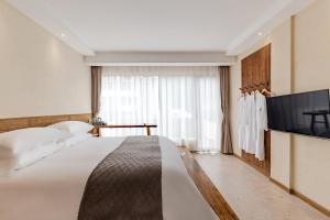 Ένα ή περισσότερα κρεβάτια σε δωμάτιο στο 问安民宿（黄山风景区店）