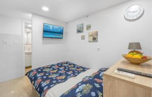 una camera da letto con un letto e una ciotola di frutta su una scrivania di Pet Friendly Apartment In Rogoznica a Rogoznica (Rogosnizza)