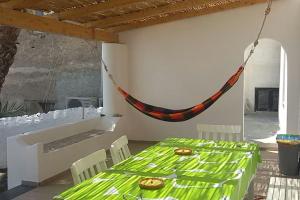 a dining room with a green table and chairs at A casa di Nino, Stromboli in Stromboli