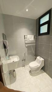 a bathroom with a white toilet and a sink at قصر أباهي للوحدات السكنية المفروشة in Al Kharj +113 photos