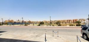 an empty parking lot with a street with buildings at قصر أباهي للوحدات السكنية المفروشة in Al Kharj