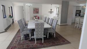 ein Esszimmer und eine Küche mit einem weißen Tisch und Stühlen in der Unterkunft The Royal Familia Beach House in Zinkwazi Beach