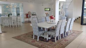 ein Esszimmer mit einem weißen Tisch und Stühlen in der Unterkunft The Royal Familia Beach House in Zinkwazi Beach